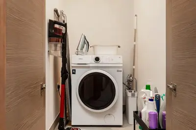 a washer and dryer in a small room at 1B with Park and Burj Khalifa View, Hartland Waves in Dubai