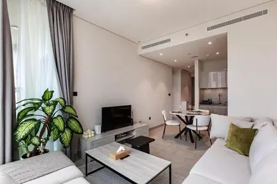 a living room with a white couch and a table at 1B with Park and Burj Khalifa View, Hartland Waves in Dubai