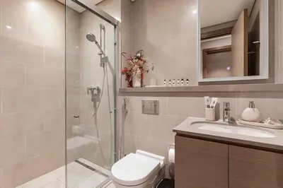 a bathroom with a shower and a toilet and a sink at 1B with Park and Burj Khalifa View, Hartland Waves in Dubai