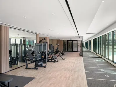 a gym with treadmills and ellipticals in a building at Elegant 1BR Living at Binghatti Emerald in Dubai