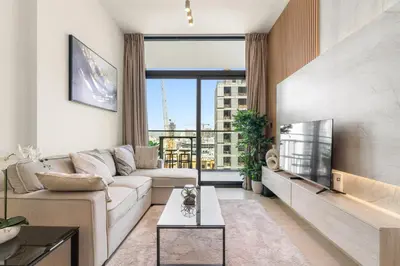 a living room with a couch and a large window at Elegant 1BR Living at Binghatti Emerald in Dubai