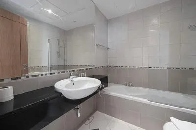 a white bathroom with a sink and a bath tub at Trident Grand! Near Beach, Pool and Gym Access! In JBR-Dubai Marina in Dubai