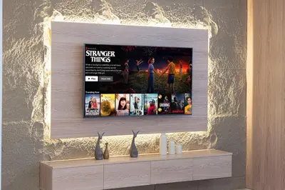 a television on a wall above a shelf with movies at Trident Grand! Near Beach, Pool and Gym Access! In JBR-Dubai Marina in Dubai