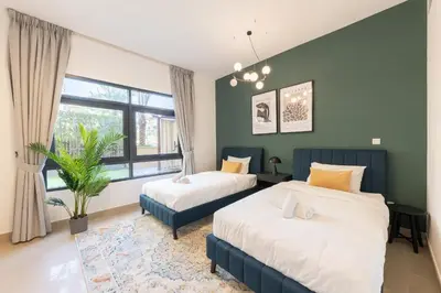 two beds in a room with green walls at Spacious 3BR with Large Terrace in Dubai