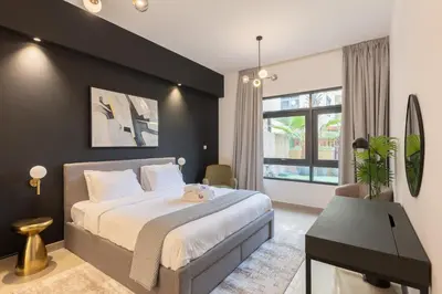a bedroom with a large bed and a desk at Spacious 3BR with Large Terrace in Dubai