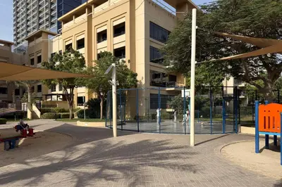 a park with a fence in front of a building at Spacious 3BR with Large Terrace in Dubai