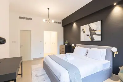 a bedroom with a large bed and a black wall at Spacious 3BR with Large Terrace in Dubai