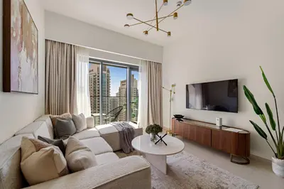 a living room with a couch and a tv at Silkhaus Luxurious 1BR with Balcony Pool and Gym Downtown in Dubai