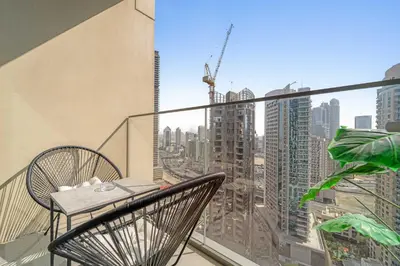 a balcony with a table and chairs and a view of a city at Silkhaus Luxurious 1BR with Balcony Pool and Gym Downtown in Dubai