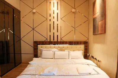 a bedroom with a large bed with white sheets at 902, Royal Residencies, Dubai Sports City in Dubai