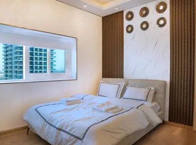 a large bed in a room with a window at 902, Royal Residencies, Dubai Sports City in Dubai
