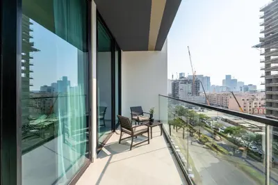 a balcony with a chair and a view of a city at GuestReady - Cozy Stay | Near Parks | JVC in Dubai