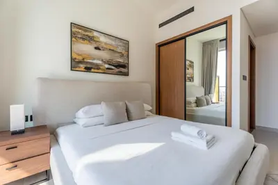 a bedroom with a white bed and a mirror at GuestReady - Cozy Stay | Near Parks | JVC in Dubai