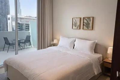 a bedroom with a bed and a balcony with a table at Burj Khalifa View Stylish 1BR in Business Bay in Dubai