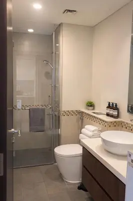 a bathroom with a shower and a toilet and a sink at Burj Khalifa View Stylish 1BR in Business Bay in Dubai