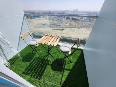 a table and chairs on a balcony with a view at Skyz by Danube, Brand new Studios in Arjan in Dubai