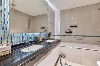 a bathroom with two sinks and a tub and a mirror at 1BR 42nd Floor Palm Jumeriah & Sea View- 5 Sleeps in Dubai