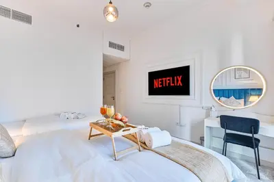 a bedroom with a bed and a desk and a tv at 1BR 42nd Floor Palm Jumeriah & Sea View- 5 Sleeps in Dubai