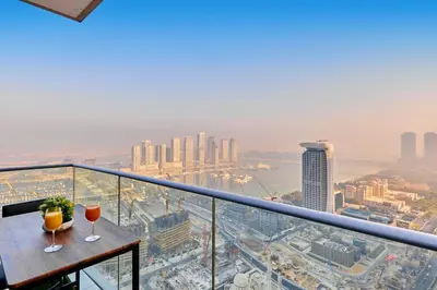 two wine glasses sitting on a table on a balcony at 1BR 42nd Floor Palm Jumeriah & Sea View- 5 Sleeps in Dubai