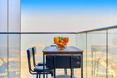 a table with two drinks and a bowl of fruit at 1BR 42nd Floor Palm Jumeriah & Sea View- 5 Sleeps in Dubai