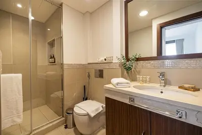 a bathroom with a toilet and a sink and a shower at Burj Vista! Great High Floor View! Mall Connected! Amazing Pool, Gym and Location! in Dubai
