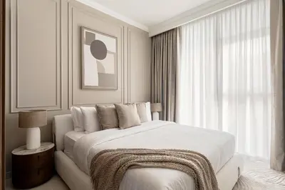 a white bedroom with a bed and a window at Beachfront 1BR with Private Beach Access Renovated in Dubai