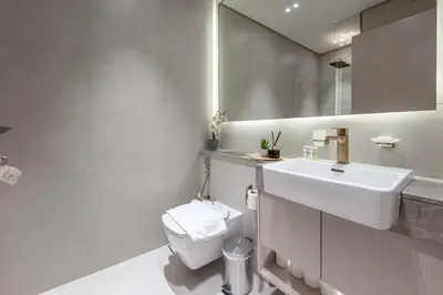 a bathroom with a sink and a toilet and a mirror at Modern and Serene Studio - JVC in Dubai