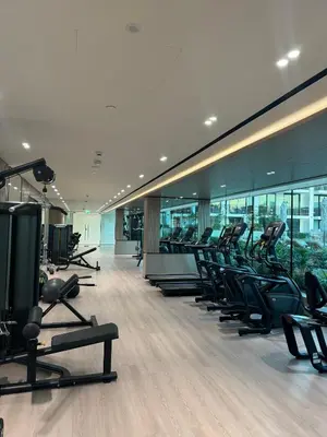 a gym with rows of treadmills and elliptical machines at Modern and Serene Studio - JVC in Dubai