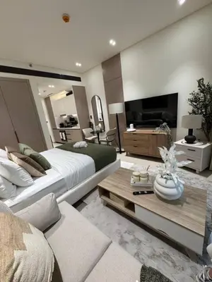 a bedroom with a large bed and a living room at Modern and Serene Studio - JVC in Dubai