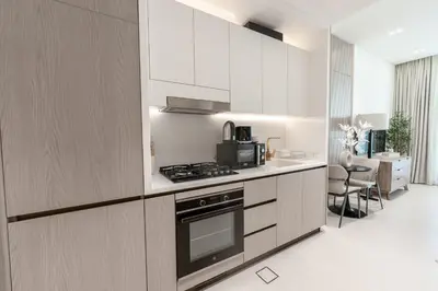 a kitchen with white cabinets and a stove top oven at Modern and Serene Studio - JVC in Dubai