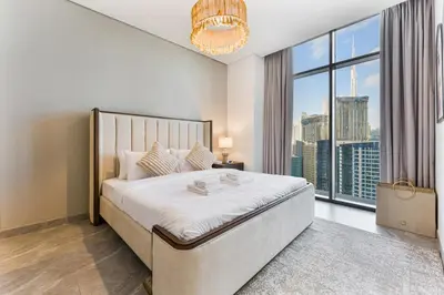 a bedroom with a large bed and a large window at Modern 2Bed with Iconic Burj Khalifa & Canal Views in Dubai