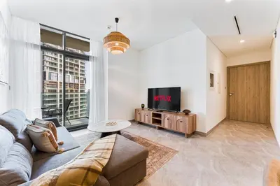 a living room with a couch and a tv at Modern 2Bed with Iconic Burj Khalifa & Canal Views in Dubai