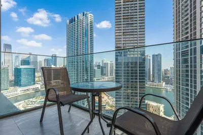 a balcony with a table and chairs and a view of the city at Modern 2Bed with Iconic Burj Khalifa & Canal Views in Dubai