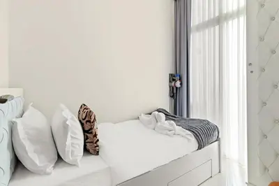 a white couch with pillows and a window at Stylish Community 2BR Avencia 2,DAMAC Hills-2 in Dubai