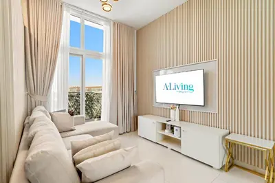 a living room with a couch and a tv at Stylish Community 2BR Avencia 2,DAMAC Hills-2 in Dubai
