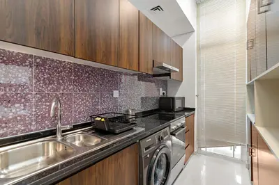 a kitchen with a sink and a washing machine at Stylish Community 2BR Avencia 2,DAMAC Hills-2 in Dubai