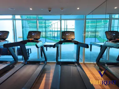 a gym with three treadmills in a building at Skyz by Danube Studio Dubai in Dubai
