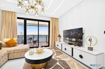 a living room with a couch and a tv at Enchanted 1BR Royal Amwaj Burj View & Private Beach in Dubai