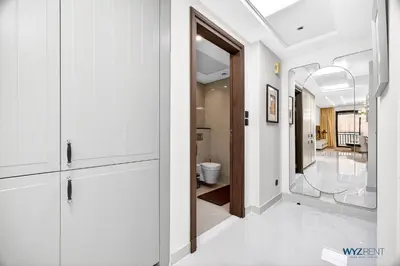 a hallway with white cabinets and a bathroom at Enchanted 1BR Royal Amwaj Burj View & Private Beach in Dubai