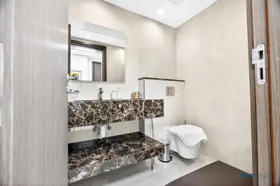 a bathroom with a sink and a toilet and a mirror at Enchanted 1BR Royal Amwaj Burj View & Private Beach in Dubai
