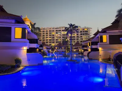 a swimming pool with blue water in front of a hotel at Enchanted 1BR Royal Amwaj Burj View & Private Beach in Dubai