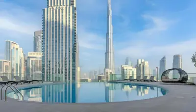 a swimming pool with chairs and a city skyline at Westminster Imperial Avenue Downtown in Dubai