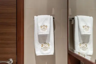 two towels are hanging on a door in a bathroom at Westminster Imperial Avenue Downtown in Dubai