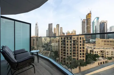 a chair on a balcony with a view of a city at Westminster Imperial Avenue Downtown in Dubai