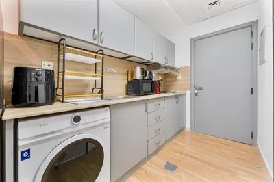 a kitchen with a washer and dryer at Chic Studio Near Circle Mall & Dubai Sports City in Dubai