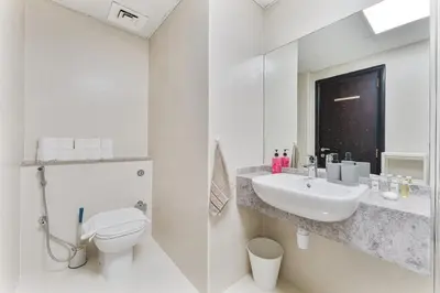 a white bathroom with a sink and a toilet at Chic Studio Near Circle Mall & Dubai Sports City in Dubai