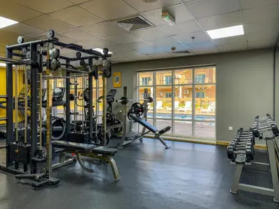 a gym with several tread machines in a room at Chic Studio Near Circle Mall & Dubai Sports City in Dubai
