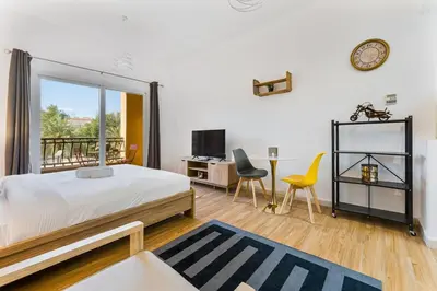 a bedroom with a bed and a table and chairs at Chic Studio Near Circle Mall & Dubai Sports City in Dubai