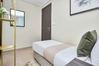 a small bedroom with a bed and a chair at Frank Porter - Sparkle Tower 1 in Dubai