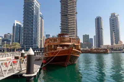 a wooden boat is docked in the water in a city at Frank Porter - Sparkle Tower 1 in Dubai